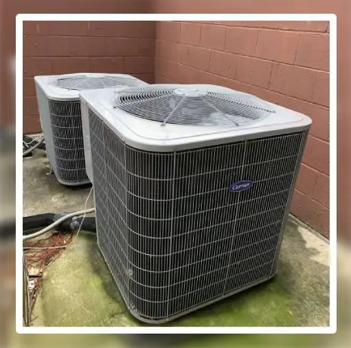 Two air conditioners are sitting outside in a room.