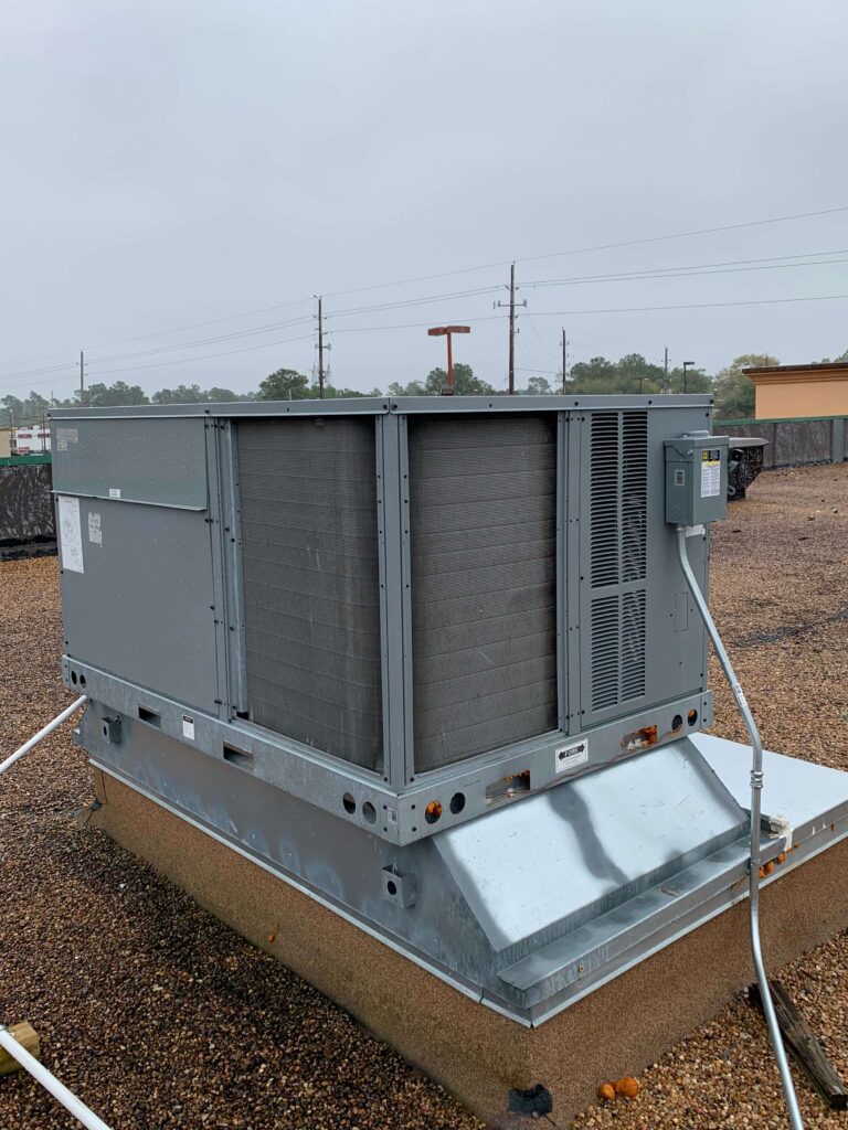 A large air conditioner unit sitting on top of a wooden box.